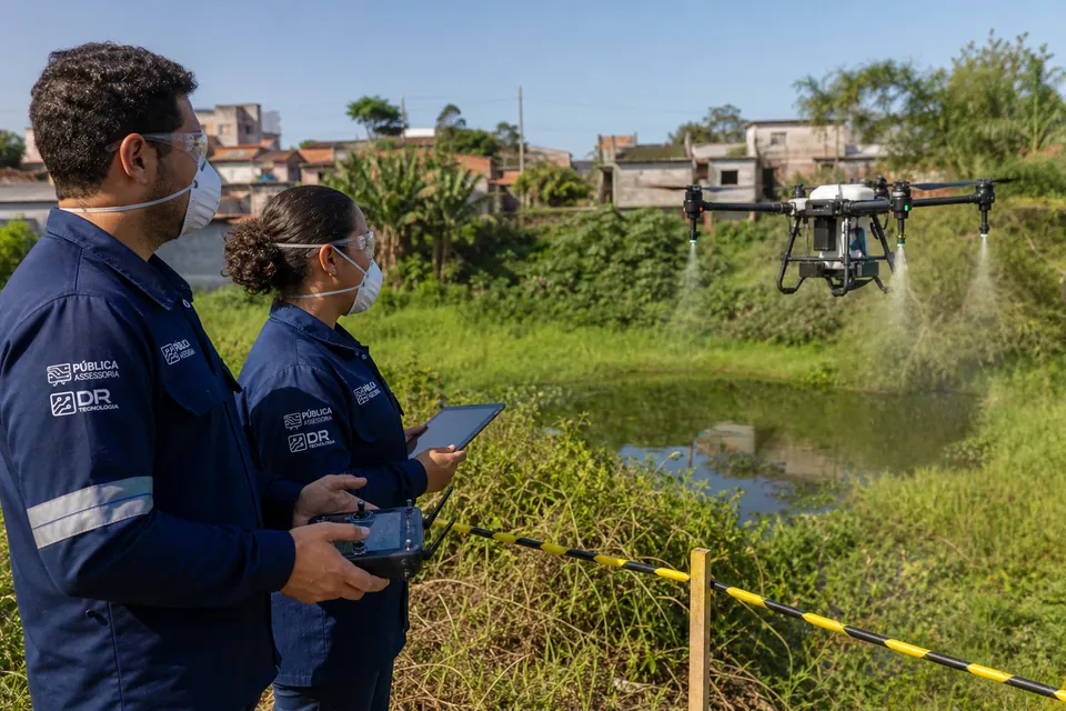 Agentes de vigilância operam um drone em uma ação controlada de combate à dengue.